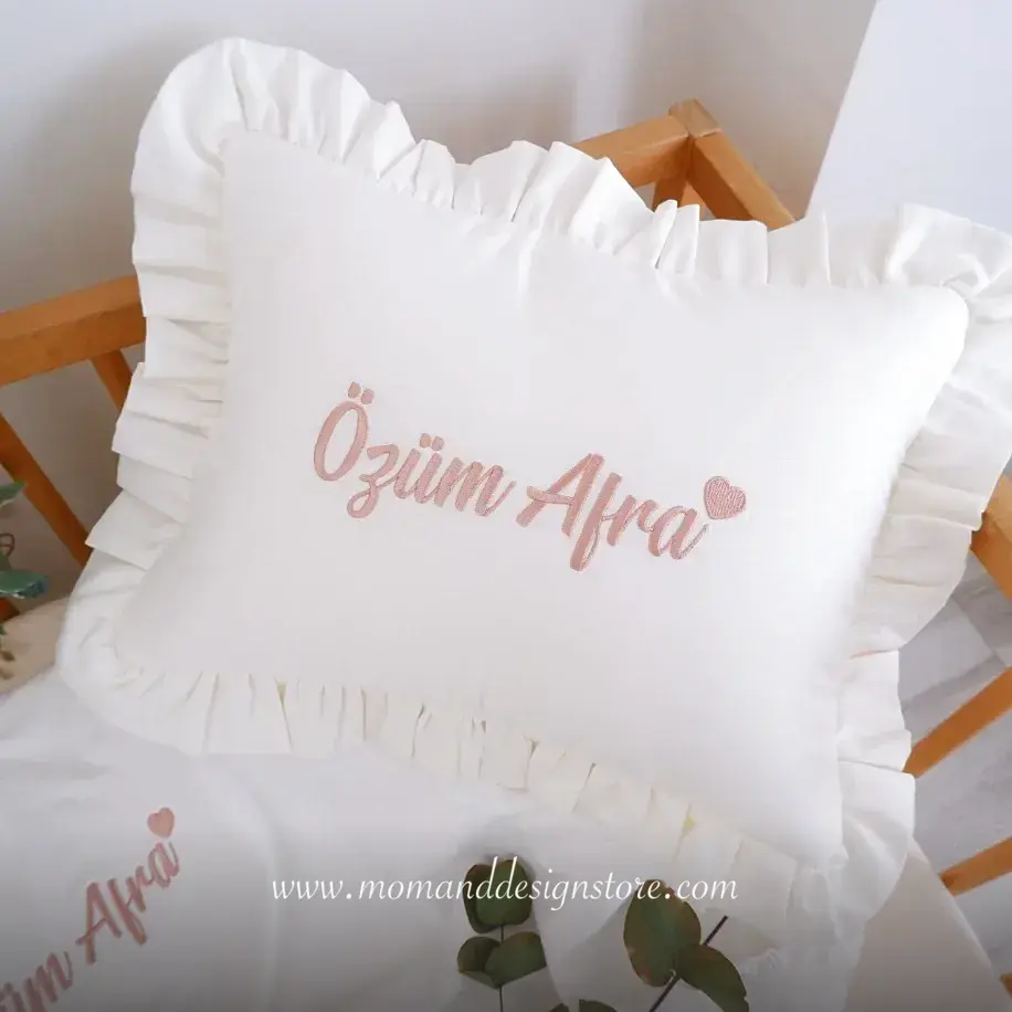 Detailaufnahme der feinen Garnstickerei auf dem fertigen Kissen im Atelier von Mom & Design